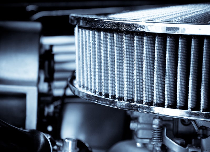 Close-up of a high-performance engine air filter with metallic housing and pleated filter element